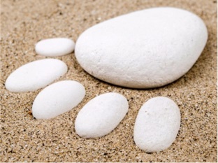 Steine im Sand in Fußform gelegt